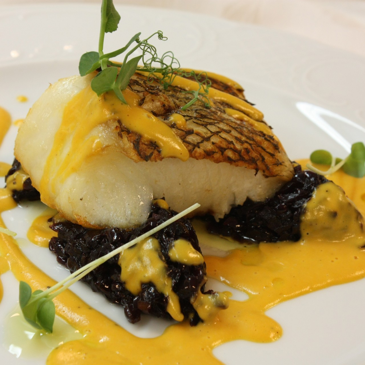 Чилийский сибасс с луковым мармеладом и пряным соусом из батата