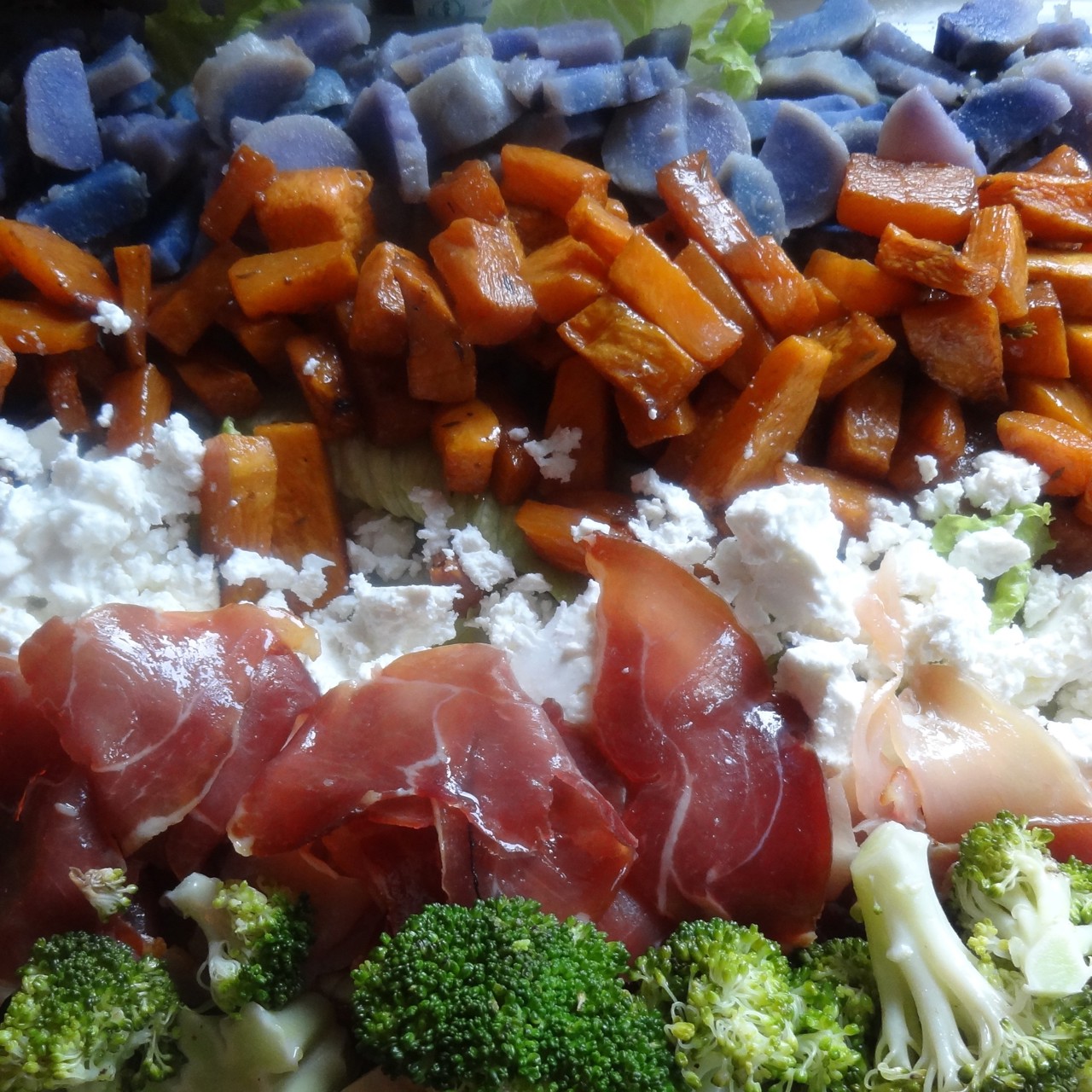 Слоеный овощной салат с прошутто и фетой на доске