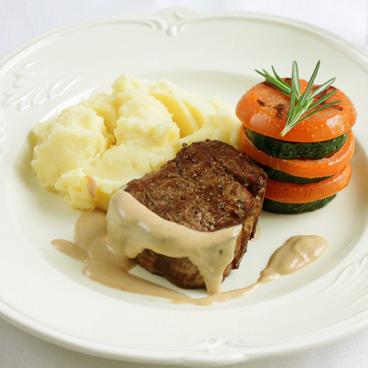 Стейк с перечным соусом, картофельным пюре и мильфеем из цукини и томатов