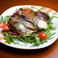 Говядина с маслом из пармезана, бальзамической глазурью на подушке из рукколы