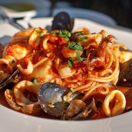 Паста с морепродуктами, зеленью и чесноком в томатном соусе