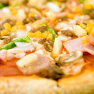 Пицца с ананасами, колбасой, сладкой кукурузой и томатами