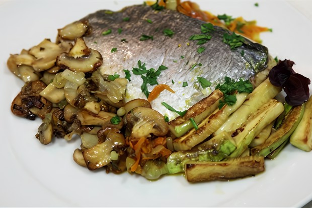 Дорада, запеченная на овощной подушке, в бумажном конверте