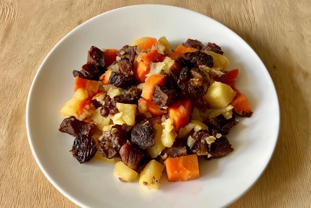 Говядина с черносливом на овощной подушке в духовке