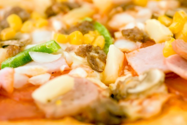 Пицца с ананасами, колбасой, сладкой кукурузой и томатами