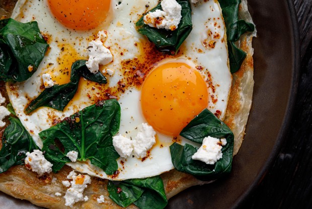 Слоеная лепешка роти с глазуньей, сыром фета, припущенным шпинатом и острым маслом