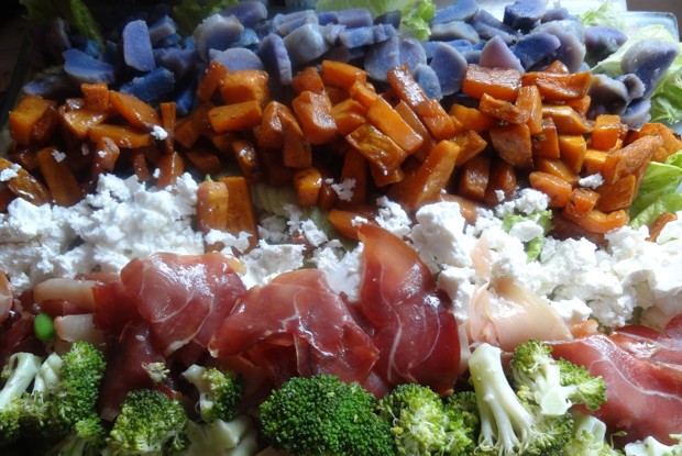 Слоеный овощной салат с прошутто и фетой на доске