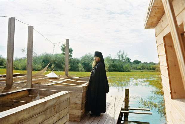 Отец Тихон инспектирует ясли для выращивания карпа. Карпам осталось жить недолго. Сейчас их в садке пятьсот штук, и в ближайший праздник их съедят.