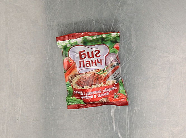 Лапша «Биг-ланч» с ароматной говядиной, грибами и зеленью — родом из города Донского Тульской области, где делается компанией, основанной вьетнамцами. Состав — едва ли не самый сложный из того, что мы попробовали. Например, ароматизатор «говядина» состоит из веществ вкусоароматических, глютамата, гуанилата, ацетата и инозината натрия, а также лимонной и уксусной кислоты (ароматизатор «грибы» чуть попроще). Но есть также молотый лавровый лист, зеленый лук, красный, черный и душистый перец, сушеные грибы, чеснок, говяжий жир, соевая паста, мускатный орех, гвоздика и тмин. Вот оно откуда — богатство вкуса. Возможны незначительные вкрапления сельдерея — но тут уж как кому повезет. Не рекомендуется (так и написано) употреблять в сухом виде. 10 рублей 33 копейки.